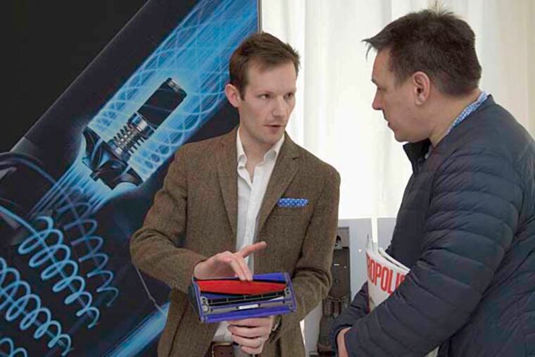 Dyson senior product designer Rob Green (left) shows off a V6 Absolute stick vac. The model worked well on embedded dirt, but the petit bagless vacuum required much bin-emptying and battery-recharging.