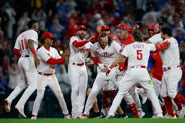 Alec Bohm (center) celebrates with his teammates after his walk-off single in the 10th inning Friday against the Mets.