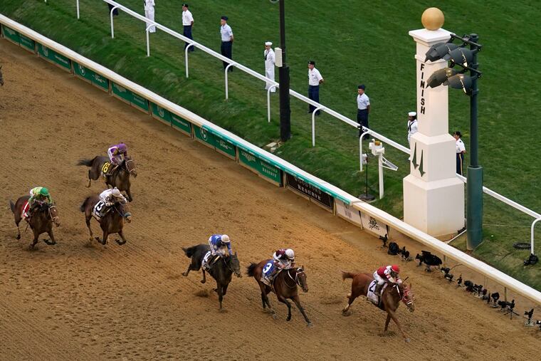 Rich Strike and jockey Sonny Leon lead the pack as they cross the finish line to win the 148th running of the Kentucky Derby at Churchill Downs on May 7, 2022.