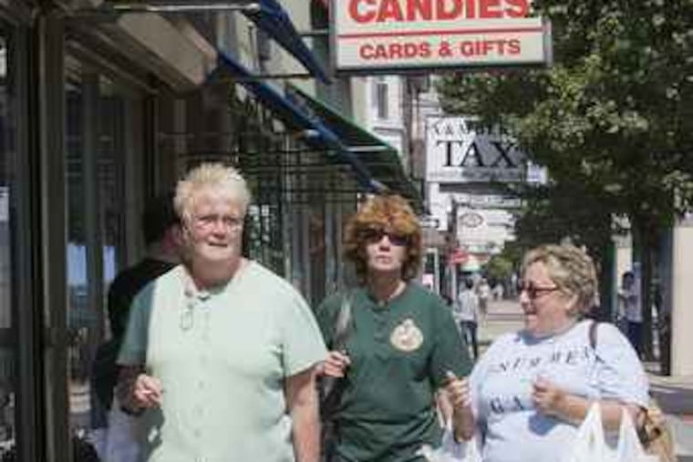 Angie O'Mara, left, Rosanne Alessio, back center, and Kit McGarry, right, use their lunchbreak to do some shopping on Frankford Ave. in Mayfair, in Philadelphia, August 13, 2008. Jessica Griffin / Philadelphia Daily News