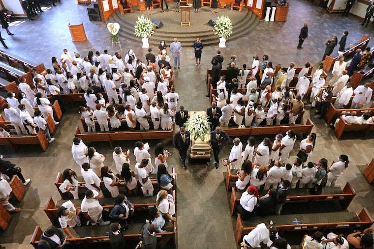 Family members dressed in while stand in respect as the body of Rayshard Brooks is carried out during his funeral in Ebenezer Baptist Church on Tuesday in Atlanta. Brooks, 27, died June 12 after being shot by an officer in a Wendy's parking lot.