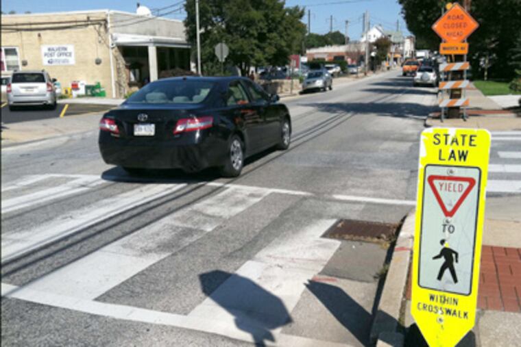 A yield-to-pedestrians sign stands at a crosswalk along King Street in Malvern. The signs are available upon request. (Tom Infield / Staff)