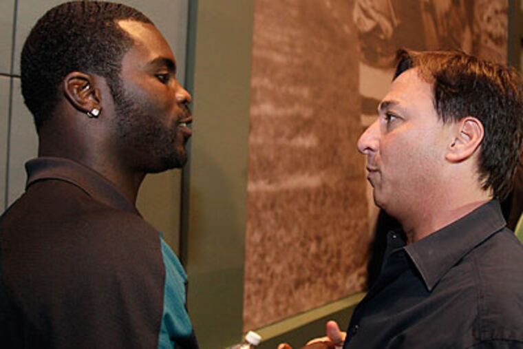 Michael Vick talks with his agent, Joel Segal, after yesterday's press conference at NovaCare. (David Maialetti/Staff Photographer)