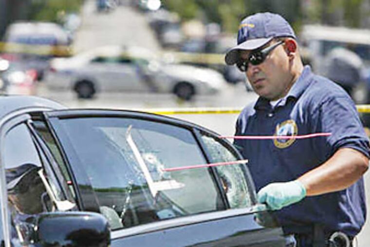 A crime-scene officer goes over the victim's car. (ALEJANDRO A. ALVAREZ / Staff photographer)