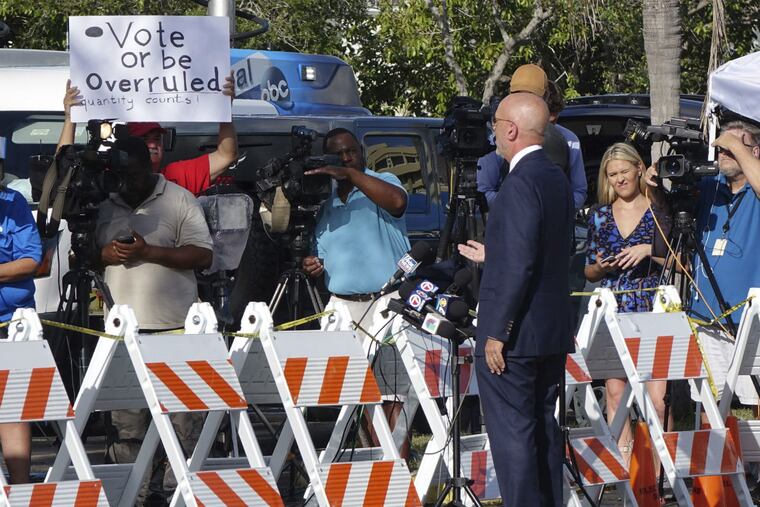 A protester holds a sign as U.S. Rep. Ted Deutch (D-Fla.)speaks Monday, Nov. 12, 2018, at the Broward Supervisor of Elections office in Lauderhill, Fla. The Florida recount continued Monday in Broward County.