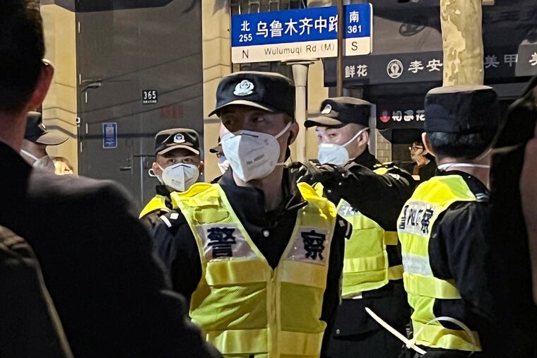 Chinese police officers block off access to a site where protesters had gathered in Shanghai on Sunday.
