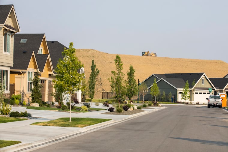 A bulldozer flattens the land to make way for more houses in Cartwright Ranch, north of Boise, Idaho.
