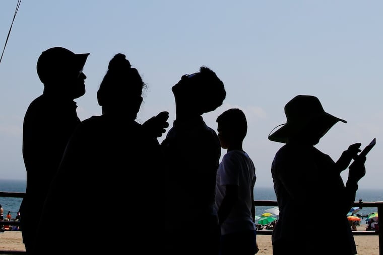 This July 2019 photo shows a family applying sunscreen before entering the beach area at Coney Island beach in New York.