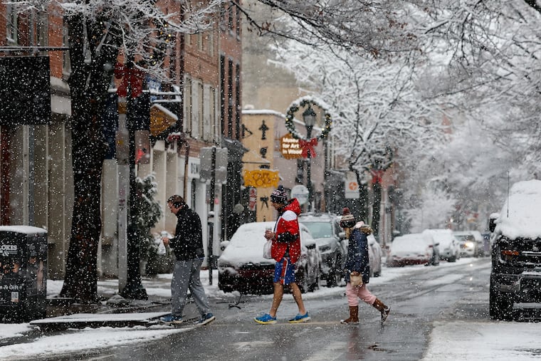 Pedestrians walk across Third Street in Old City as snow fell on Dec. 14.