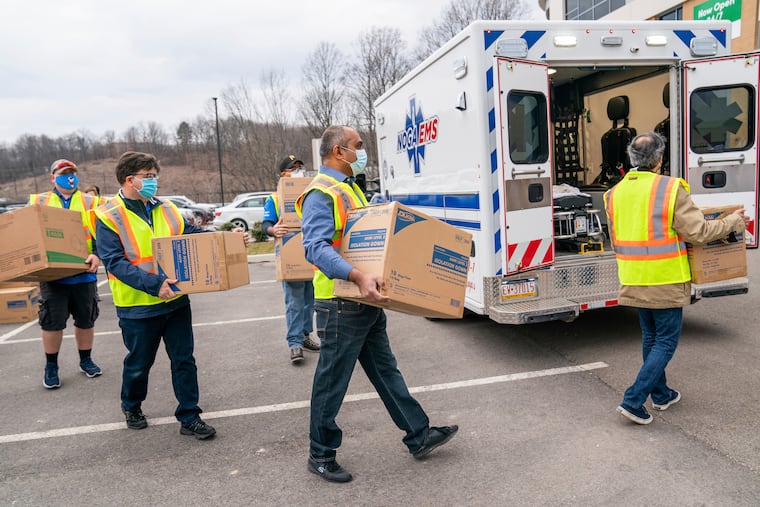 Allegheny Health Network employees load boxes of Personal Protective Equipment (PPE) for local EMS agencies during a drive-up event at AHN McCandless Neighborhood Hospital on Thursday, March 11, 2021. The day's distribution included N95 masks, surgical masks, face shields and surgical gowns. (Andrew Rush/Pittsburgh Post-Gazette via AP)