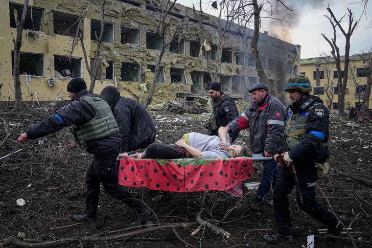 Ukrainian emergency employees and volunteers carry an injured pregnant woman from a maternity hospital that was damaged by shelling in Mariupol, Ukraine, last week. The woman and her baby died.