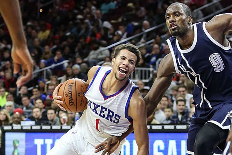 Sixers' Michael Carter-Williams gets fouled by Oklahoma City Thunder forward Serge Ibaka during the 4th quarter at the Wells Fargo Center in Philadelphia. (Steven M. Falk/Staff Photographer)
