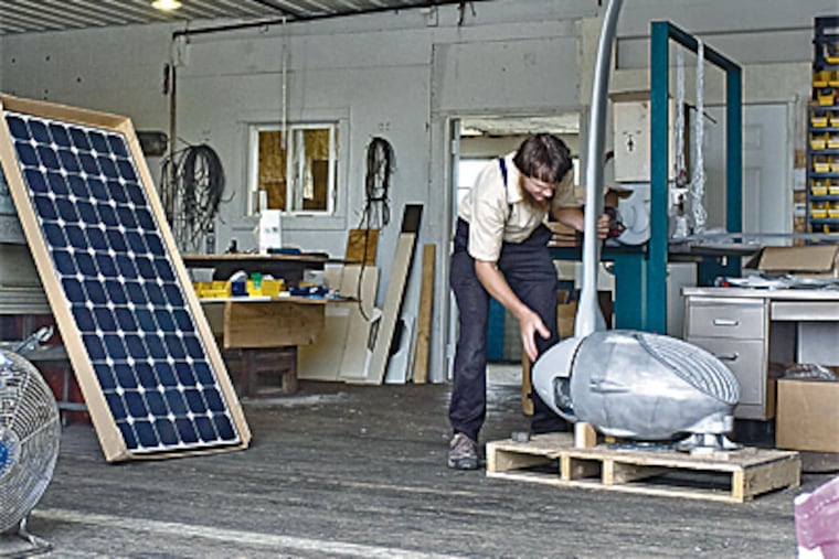 Elam Beiler works on a wind turbine in the shop of his Advanced Solar Industries firm in Ronks, Lancaster County. Beiler has been selling solar products for 15 years. (Clem Murray / Inquirer)