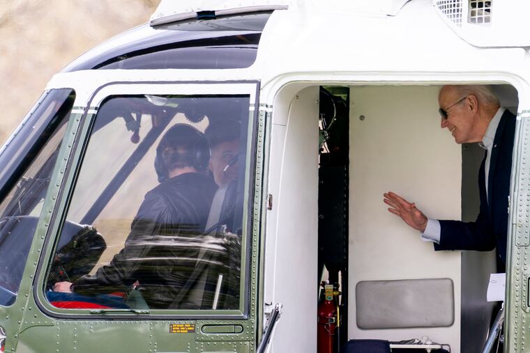 President Joe Biden waves to the pilots on Marine One as he arrives at the White House in Washington, Sunday, March 20, 2022, after spending the weekend in Rehoboth Beach, Del.
