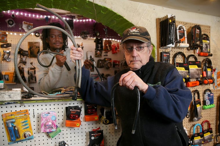 Owner Jeff Harris, right, and apprentice mechanic Kevin Bass hold up cut bike locks at Frankinstien Bike Worx on Spruce Street on Dec. 17.