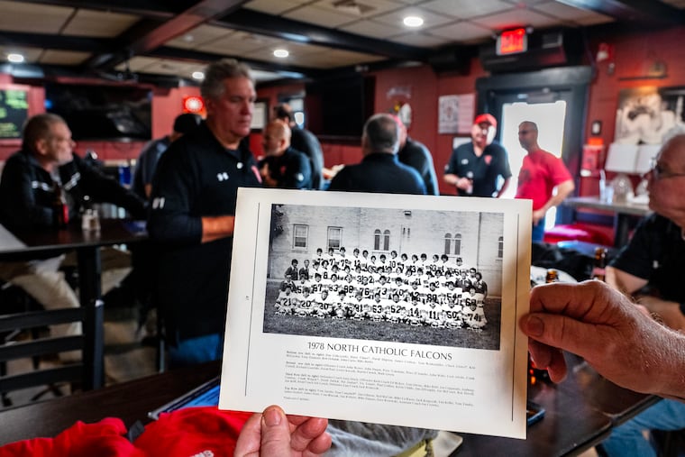 Former North Catholic football player John Kane holds a 1978 team photo while former teammates gather at Dagwood's Pub in Torresdale on Nov. 16.