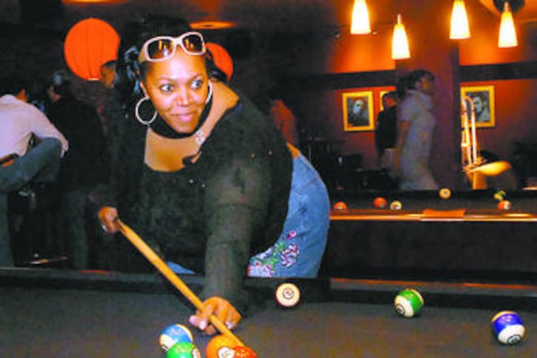Carmen Allen shoots pool during the ModSpace party. Such parties can save companies money, but are seen as having other benefits as well.