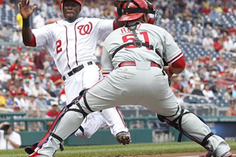 Washington's Roger Bernadina slides into home plate to score as Phillies catcher Carlos Ruiz waits for the throw. (Manuel Balce Ceneta/AP)