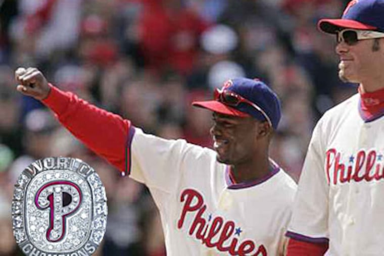 Jimmie Rollins shows off his ring to the crowd in April, as Jayson Werth, right, watches. Inset: The World Series ring. ( Michael Bryant / Staff photographer )