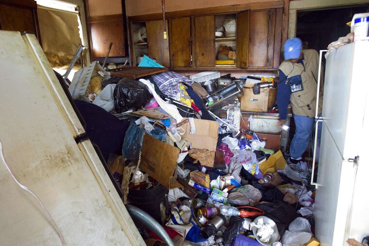 Lauren Mosely, a Chicago building inspector, examines the huge mess found in the kitchen of an elderly couple who were hoarders.