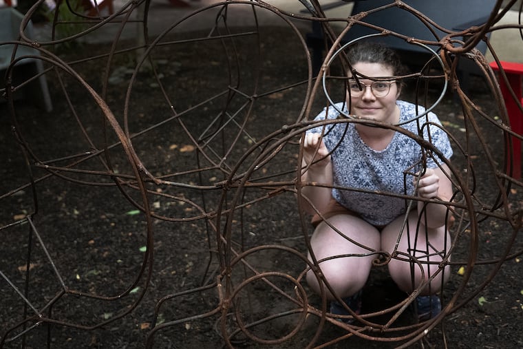 University of the Arts student Zivia Brown pose for a photo with her steel goat statue minutes before removing it from a university courtyard.