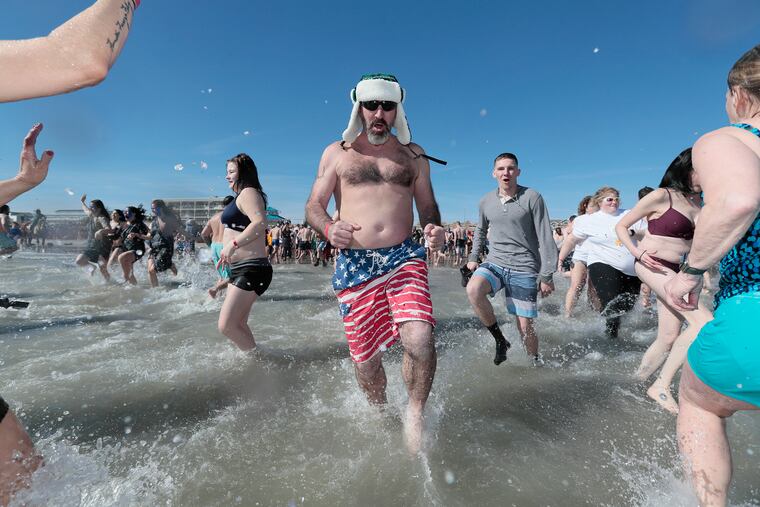 Sea Isle City’s polar bear plunge is off and running as people race into the frigid Atlantic Ocean in Sea Isle City on Saturday morning.