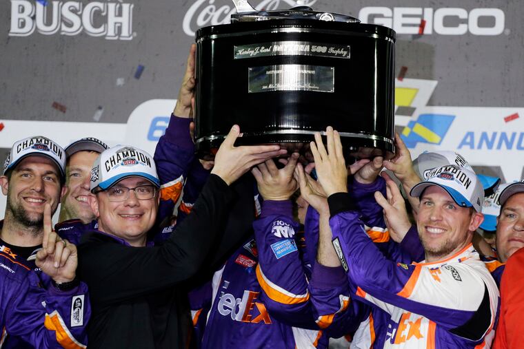 Denny Hamlin, right, celebrates as he and crew members hoist the championship trophy after winning the NASCAR Daytona 500 auto race at Daytona International Speedway, Monday, Feb. 17, 2020, in Daytona Beach, Fla.