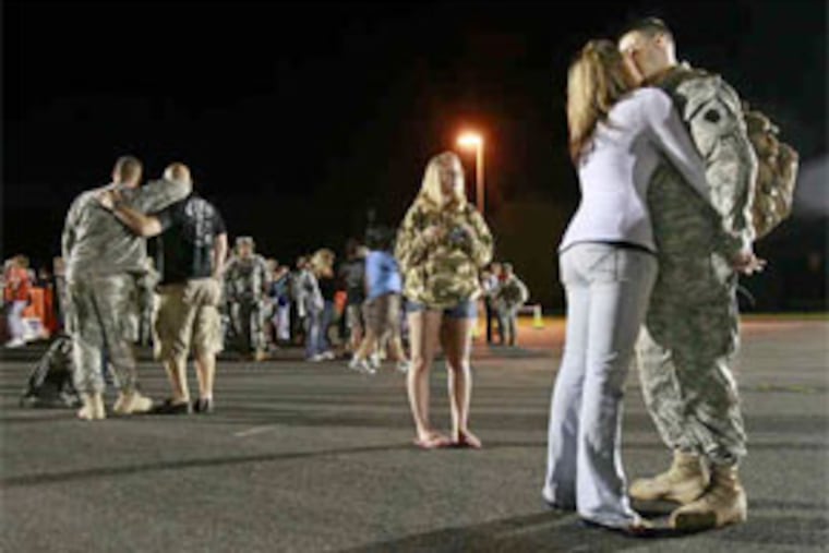Spec. Dan Kovac and his wife, Tara, of Bellwood, Pa., kiss at Fort Dix. Three hundred guardsmen came home early yesterday. (Elizabeth Robertson / Staff Photographer)