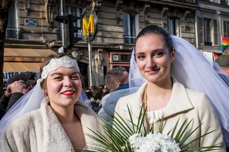 Two women pose during a demonstration in Paris in support of same-sex marriage and adoption.