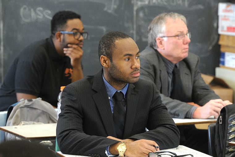 Former students Jamar Saunders (foreground), 22, Brian Foster (back left), 22, and Gregg Volz, Director of the Youth Court Support Center at Education Works, Inc. monitoring the Chester High School Youth Court class on April 30, 2015. ( CLEM MURRAY / Staff Photographer )