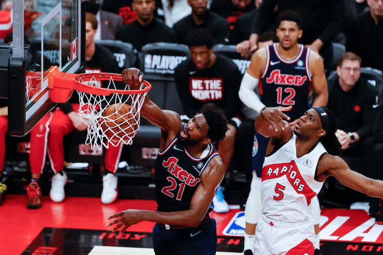 Sixers center Joel Embiid dunks the basketball past Toronto Raptors forward Precious Achiuwa in the fourth quarter during game six of the first-round Eastern Conference playoffs on Thursday, April 28, 2022 in Toronto.