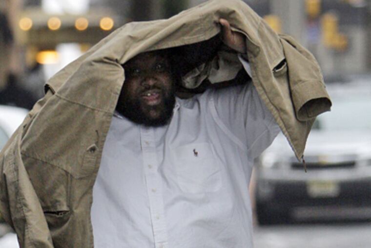 Dwight Dixon looks up from under his jacket after exiting the Criminal Justice Center in Philadelphia on Jan. 28, 2009. (AP File Photo)