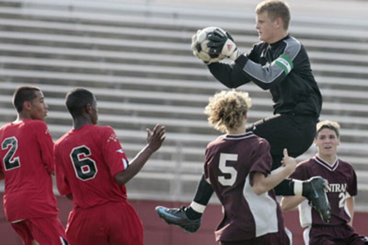 Northeast's Santiago Ossa and Mohamed Ahmed watch as Northeast goalkeeper Tim Freiling makes a save in between Central players Graham Johnston and Jim Andrews during a boys soccer game Monday. Central won, 2-1. (Elizabeth Robertson / Inquirer)