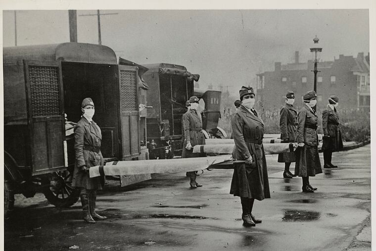 St. Louis Red Cross Motor Corps personnel hold stretchers next to ambulances in preparation of receiving victims of the influenza epidemic in October 1918. MUST CREDIT: Library of Congress