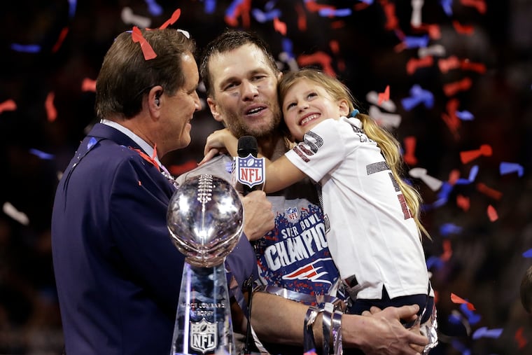 Tom Brady holds his daughter, Vivian, while speaking with Jim Nantz after the Patriots won their sixth Super Bowl -- this one against the Rams.