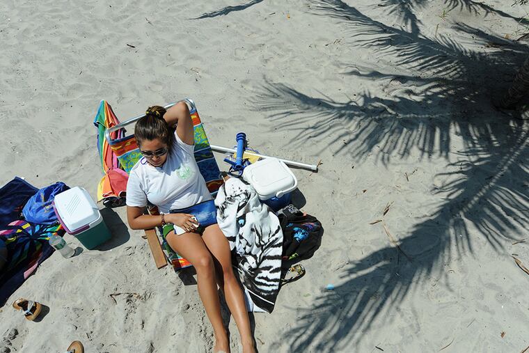 Angelica Jimenez, 19, of St. Petersburg, Fla., is a Margate City beach tag checker. She’s relaxing in the sun at the Benson Avenue entrance. (Clem Murray / Staff Photographer)