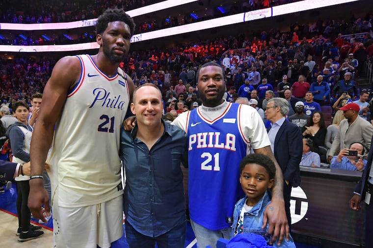 Joel Embiid (from left) #21 of the Philadelphia 76ers, co-owner Michael Rubin, Meek Mill and his son Papi pose for a photograph after a game against the Miami Heat in 2018.