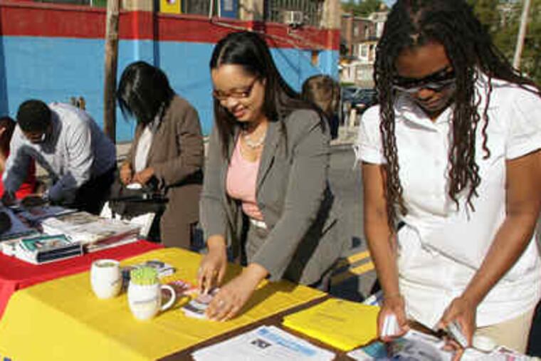 Volunteers help organize a table with information for the street rally for education yesterday.
