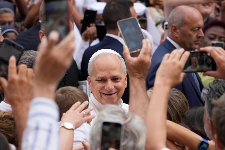 Pope Leo XIV is greeted by faithful as he arrives at the St. Thomas of Villanova Church to celebrate a mass, in Castel Gandolfo, in the outskirts of Rome, Friday, Aug. 15, 2025. (AP Photo/Gregorio Borgia)
