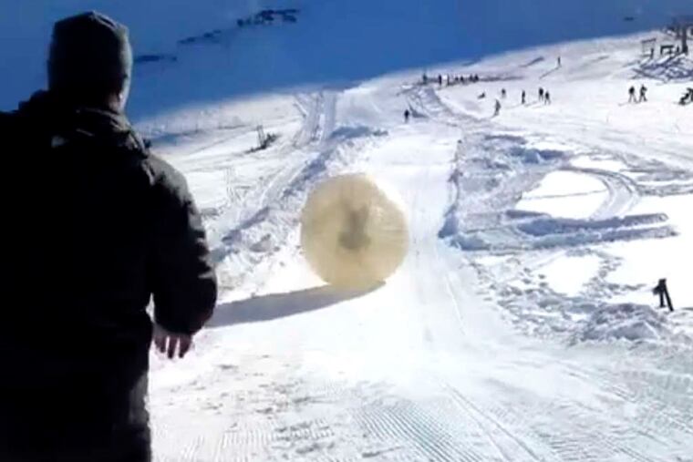 In a frame grab from video provided by the victim's wife, the zorb speeds down the slope with the two men inside.