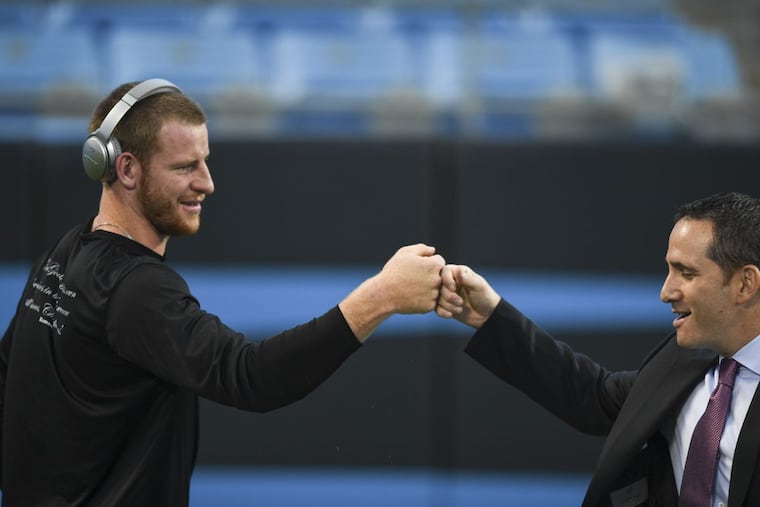Eagles quarterback Carson Wentz fist bumps with Eagles executive vice president of football operations Howie Roseman prior to the game against the Carolina Panthers October 12, 2017 at Bank of America Stadium.
