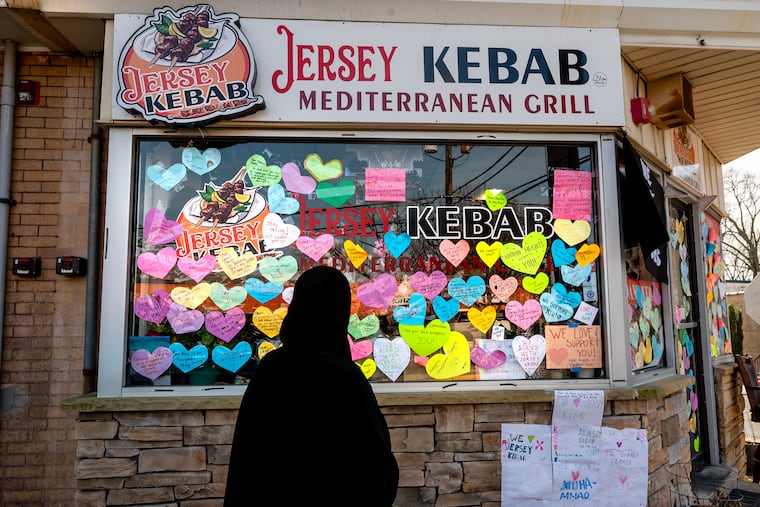 Emine Emanet reads the many notes left by supporters on the windows of her family's Jersey Kebab restaurant in March, the day after she was released from ICE detention. She and her husband were arrested by ICE in February.