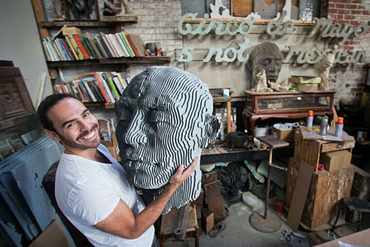 Artist Miguel Horn, founder of Traction with a giant head made of c and c cut cardboard. ( ALEJANDRO A. ALVAREZ / Staff Photographer )