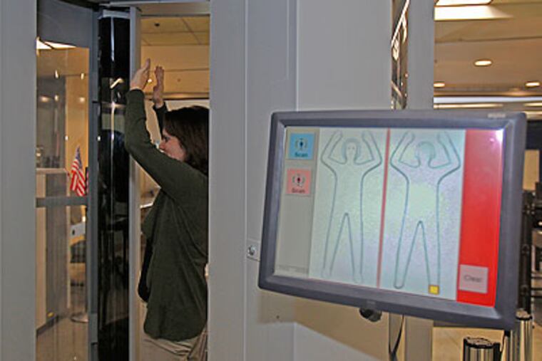 Carol Fedrizz, of Syracuse, N.Y., goes through a new X-ray scanner Thursday at F-Terminal of Philadelphia International Airport. (Akira Suwa / Staff Photographer)
