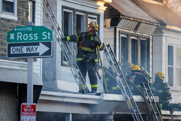 Firefighters respond to a two-alarm rowhouse fire on the 500 block of High Street in East Germantown on Tuesday.