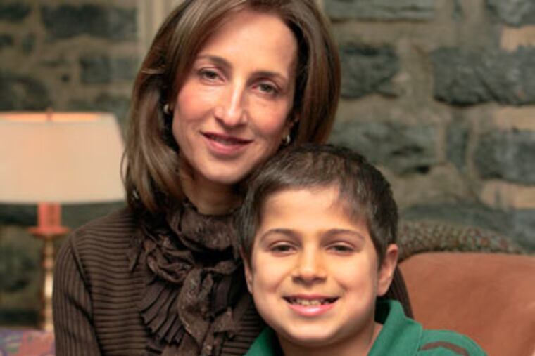 Amber Salzman and son Spencer Barsh, 9, in their Merion home. He is healthy today, having received umbilical-cord stem cells. His mother and aunts have fought hard for genetic therapy to save those with his condition.