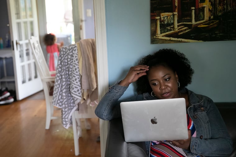 Bethany Watson-Ostrowski takes a Zoom call with her boss while her youngest daughter, Julie Ostrowski, 3, plays around their Cheltenham home.