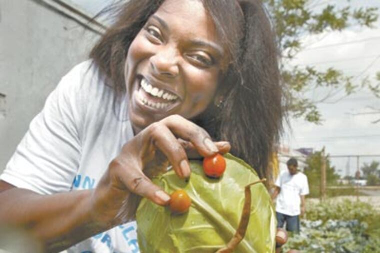 A smile on her cabbage brings one to Asia Sellers’ face. She decorated it while working in Woodland community garden. (Elizabeth Robertson / Staff Photographer)