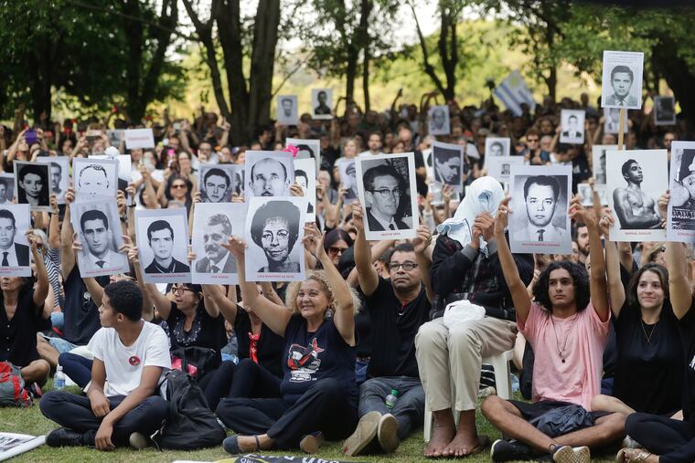 Demonstrators hold photos of persons who were killed during Brazil's dictatorship during a protest in Sao Paulo, Brazil, Sunday, March 31, 2019. Over the objections of human rights groups but with the support of far-right President Jair Bolsonaro, some military bases are commemorating the March 31, 1964 coup that lasted two decades in Brazil and made thousands of victims. (AP Photo/Andre Penner)