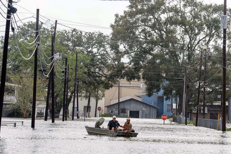 Boaters navigate a flooded road Thursday in Delcambre, La., after Hurricane Laura hit.